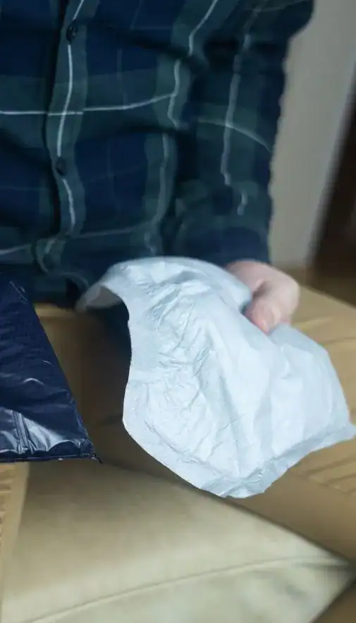 Image of man holding incontinence pads as part of overactive bladder treatment Cardiff